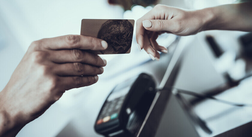    Женщина передает карту в руки продавцу — так делать не стоит. Фото: Depositphotos
