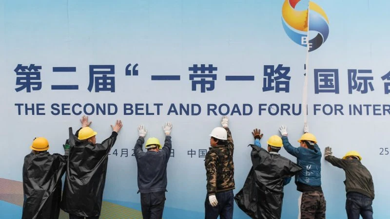 Рабочие снимают панель форума «Один пояс, один путь» возле места проведения форума в Пекине, 27 апреля 2019 г. (GREG BAKER/AFP через GettyImages)