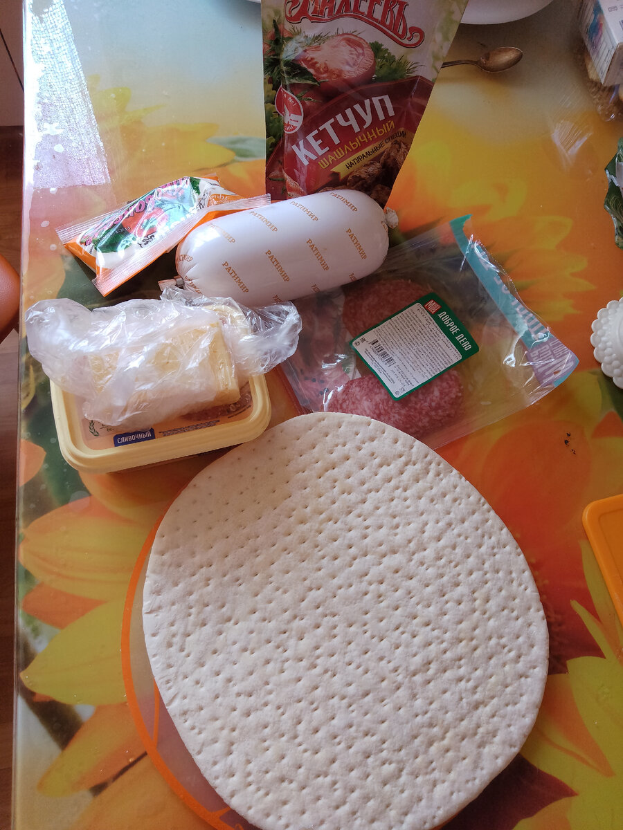 1. Для этого нам понадобится основа для пиццы, сыр, кетчуп, колбаса, майонез, зелень. 