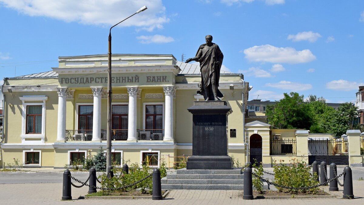 Александровская площадь
Архитектурной доминантой Банковской площади первоначально был Александро-Невский Иерусалимский греческий мужской монастырь, основанный в 1814 году. 
В 1825 году в Таганроге скоропостижно скончался Александр I, его забальзамированное тело со 2 по 29 декабря было помещено в монастырь. В 1831 году по просьбам таганрожцев на площади перед монастырём был установлен памятник Александру I. Торжественное открытие состоялось 11 октября. В 1837 году вокруг памятника установили чугунные тумбы и обнесли цепями. В 1855 году вокруг монумента был разбит сквер. На трёх других углах площади находились частные особняки. Позже на их месте в разное время были построены здания Городского Общественного банка (1863), таганрогского отделения петербургского учётно-ссудного банка (1895) и биржевого общества (1910-е) В 1920-е годы монастырь был закрыт и снесён.
В 1932 году памятник Александру I был демонтирован и отправлен на переплавку, а его пьедестал использовали для монумента «Борцам революции», установленного на старом городском кладбище.  В 1998 году, к 300-летию Таганрога, памятник императору с небольшими изменениями был восстановлен и возвращён на историческое место.