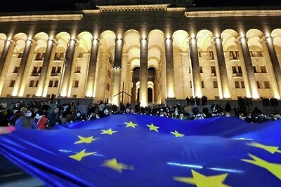    Участники акции протеста разворачивают флаг Евросоюза у здания парламента Грузии в центре Тбилиси. © РИА Новости