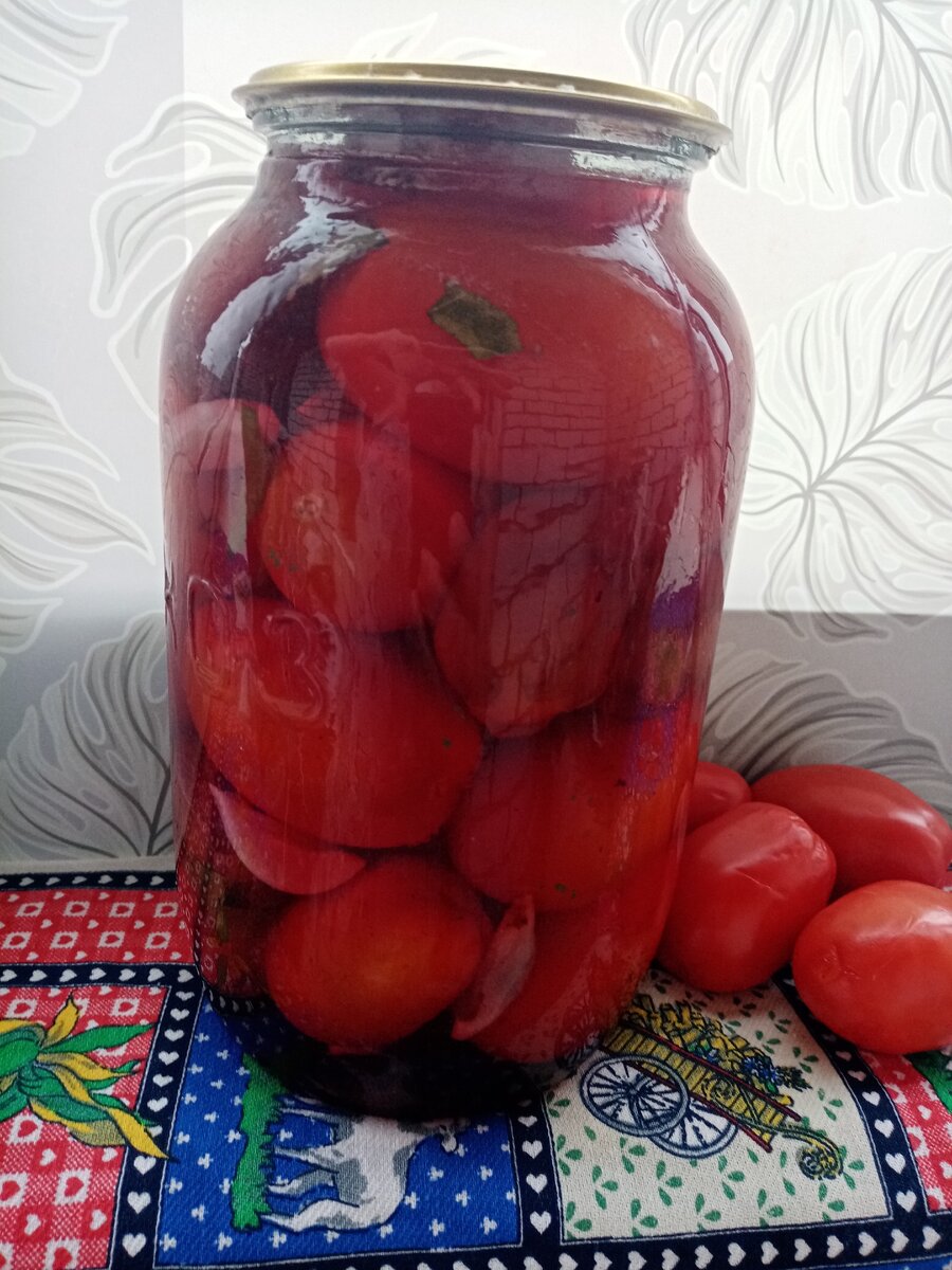 Заготовка выглядит привлекательно и имеет кисло-сладкий пряный вкус.   Сливы придают томатам пикантности и сами по себе очень вкусны . Пряности хорошо дополняют фруктово-овощной аромат. 
Для начала приготовим банки для консервирования. Промоем их с содой, простерилизуем в кипятке, ошпарим кипятком крышки.  

Из расчета на 3-х литровую банку потребуется:

1 столовая ложка с горкой соли
150 грамм сахара
70 грамм 9 % столового уксуса                                                                                                                             2-3 зубчика чеснока                                                                                                                                                       2 бутона гвоздики                                                                                                                                                корица на кончике ножа                                                                                                                                             2-3 горошины душистого перца                                                                                                         лавровый лист                                                                                                                                                            щепотка зерен горчицы                                                                                                                                  Набор специй можно дополнить или сократить по своему вкусу                                                                                                                                 
В подготовленные банки укладываем на дно зубчики чеснока и специи. Заполняем банку до верха спелыми томатами среднего размера и  сливами в пропорции 3/1. Заливаем на 20 минут крутым кипятком. Сливаем воду в раковину. Снова заливаем в банку кипяток, сливаем его минут через пять в кастрюлю и делаем на нем рассол из соли , сахара и уксуса, доводим до кипения . Кипящий рассол заливаем в банку, закатываем, переворачиваем и тепло укутываем до остывания.