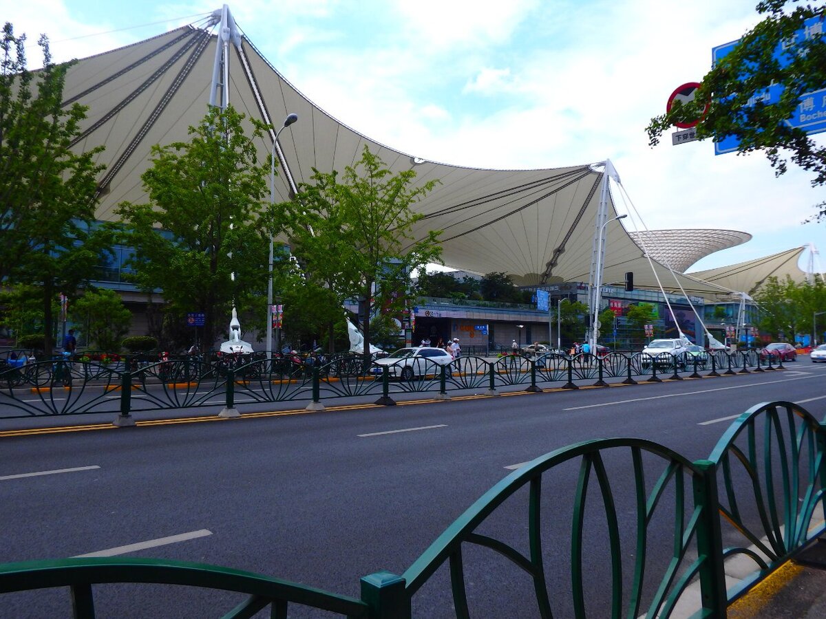  Expo Axis - это центральное здание Экспо-2010. Его крыша, выполненная в виде мембран, самая крупная в своем роде. Сейчас здесь располагается ТРЦ River mall. Если вы решили посетить, музей современного искусства, то сюда нужно зайти обязательно. Самое главное - это смотровая площадка, откуда видна крыша здания во всей красе.
Вид со смотровой площадки.


Как добраться
Станция метро China Art Museum. Выход 3. Далее по указателям к River mall. Как зайдете в ТРЦ, поверните направо. Далее вам нужно пройти несколько павильонов и вы попадете к цели.
Вид на сооружение с улицы не впечатляет.

