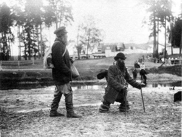 Два странника идут по берегу реки в Саровский монастырь: безногий ведет слепого за веревочку, 1903 год.
