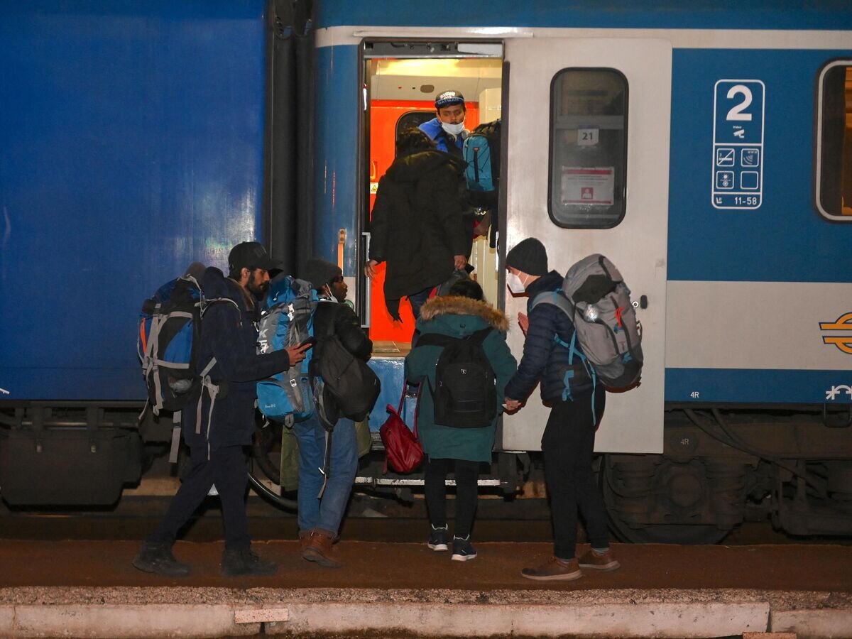    Украинские беженцы садятся в поезд, идущий в Будапешт, на железнодорожной станции Захонь, недалеко от венгерско-украинской границы© AFP 2023 / ATTILA KISBENEDEK