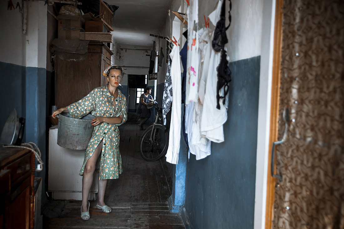 Советская женщина развешивает стирку в коммунальной квартире.