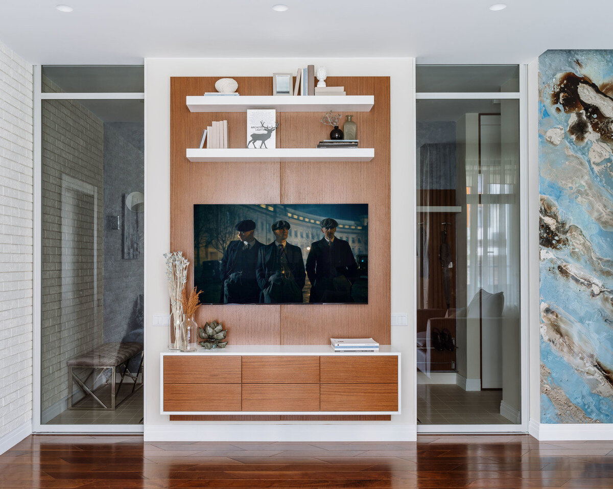 ТВ-зону оформили панелями из натурального шпона ореха. С ними перекликаются фасады подвесной тумбы.