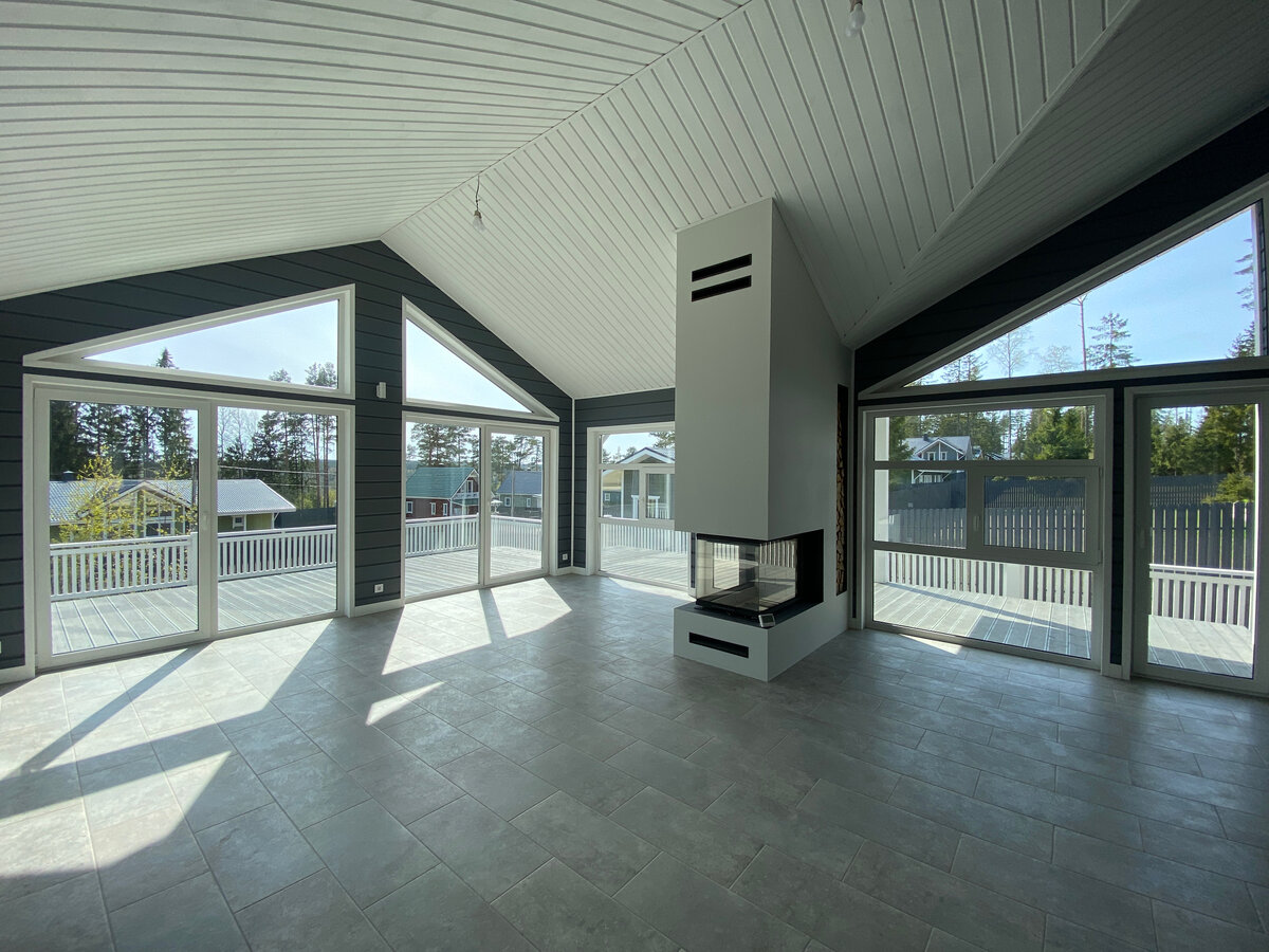 Гостиная с панорамными окнами и дизайнерским камином в коттедже "Еквик"