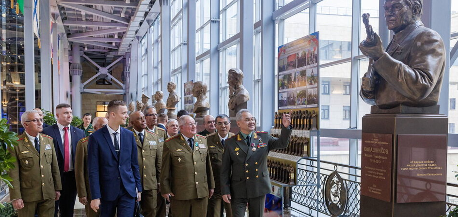 Сергей Шойгу и Альваро Лопес Миера перед бюстом советского конструктора оружия Калашникова (Москва, 27.6.2023) 