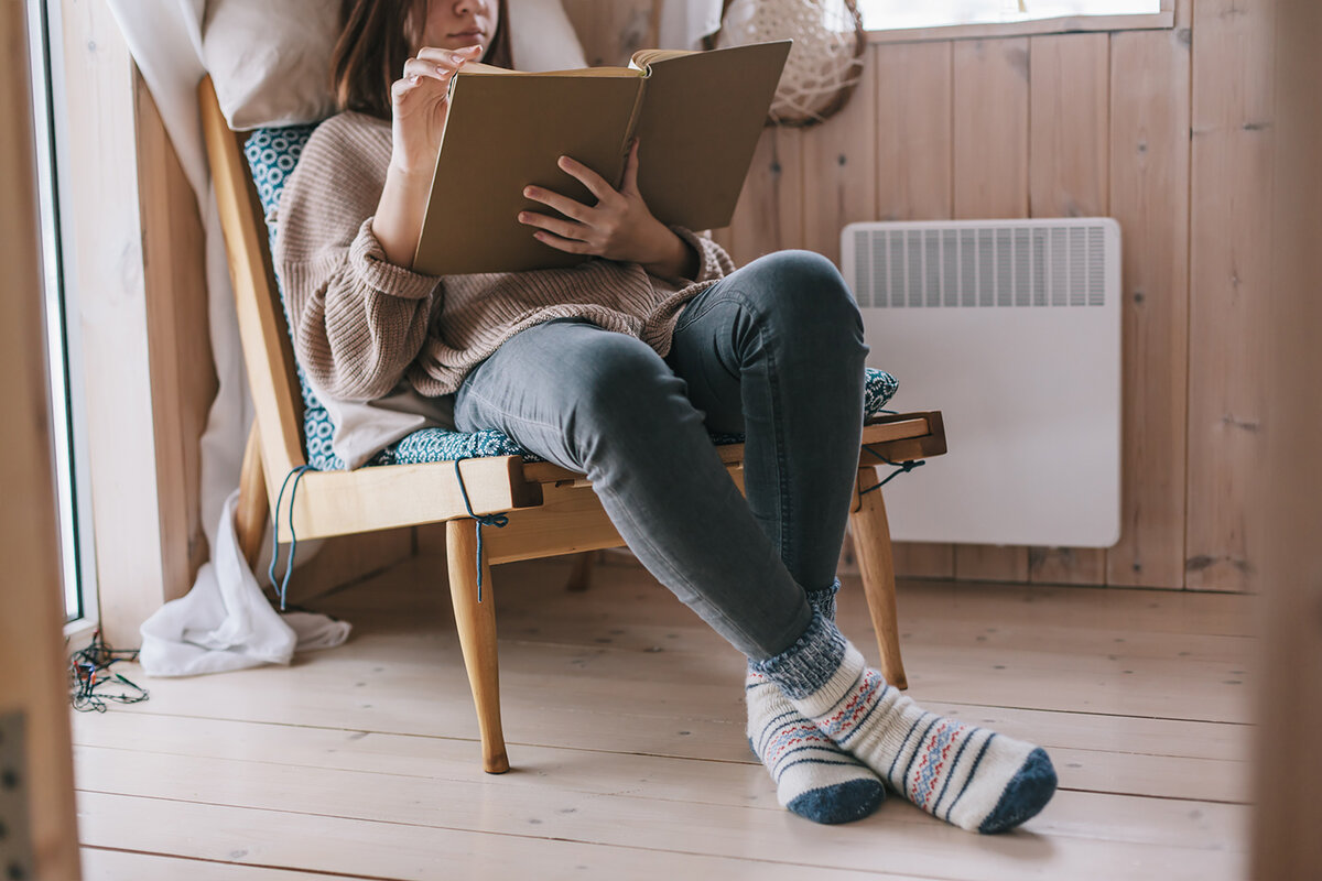 Удобно читаемой. Девушка в свитере читает. Read Sweater. Young woman Relaxed at Heater with Tablet in hand.