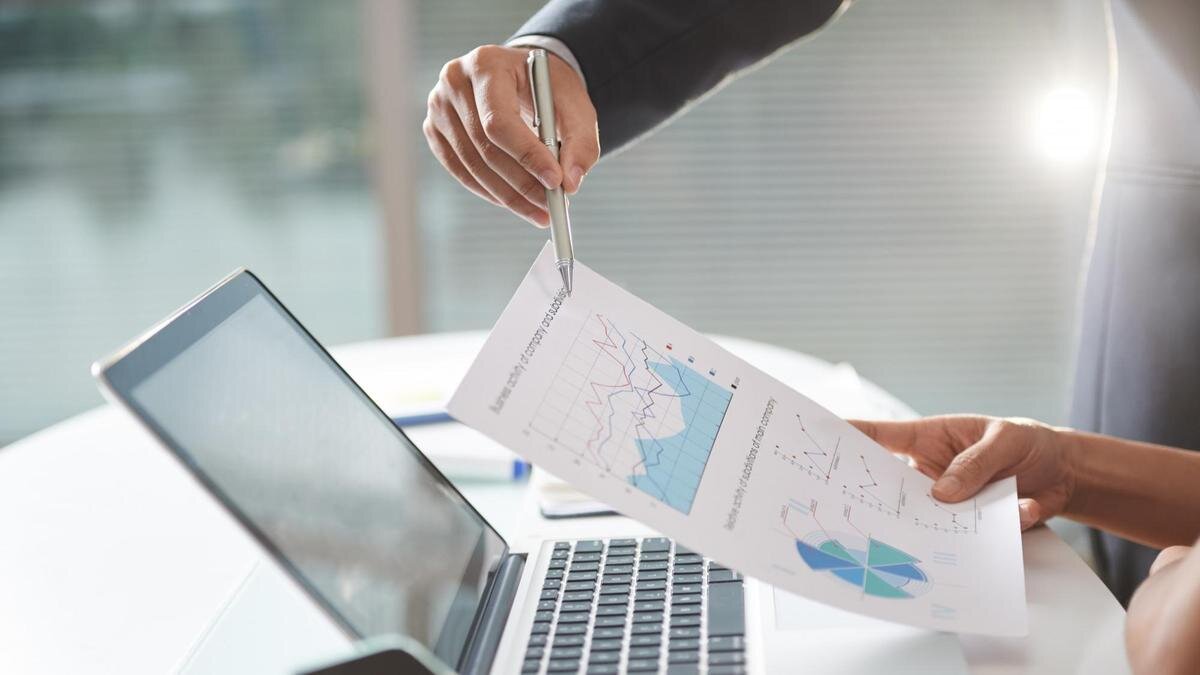    Одна рука держит лист с графиком, другая указывает в него ручкой:Freepik/pressfoto