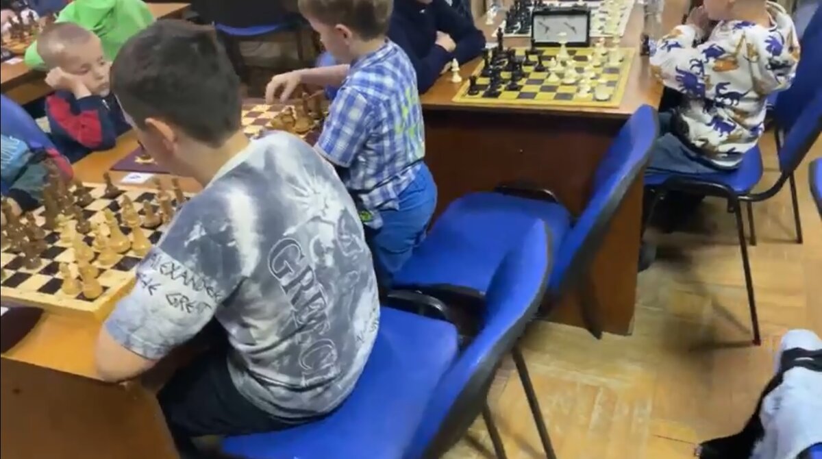 Дети играют в шахматы в библиотеке.