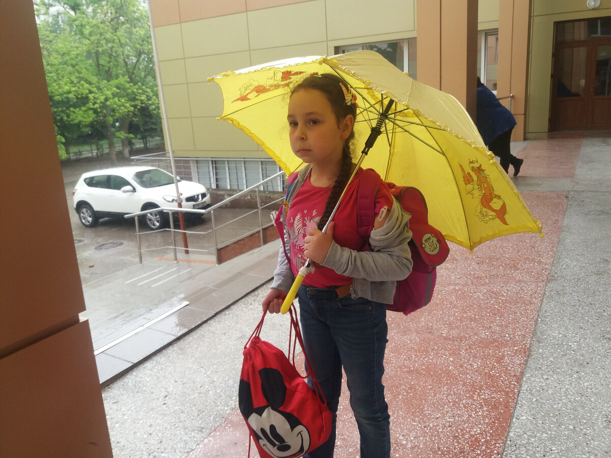 Женя на пороге школы. На прошлой неделе ливень шёл, дед зонтик принёс.