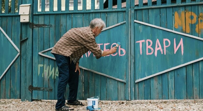 На окраине Смоленска была деревня Занозино: несколько домов рядом с дремучим лесом, разрушенная церковь, старожилов дай бог с два десятка наберется. Все поголовно старики, как оно в деревнях и принято. Среди прочих здесь проживал и старый егерь Захар Занозин. Его род в этих местах обитал несчетное количество поколений, вот фамилия и слилась с местом пребывания. А потом в деревню нагрянул тучный бизнесмен Роберт и сделал жителям предложение, от которого невозможно отказаться: дома отправляются под снос вместе с церковью, лес вырубается. За молчаливое согласие с таким раскладом каждому деревенскому выделят по квартире в свежих новостройках ЖК «Смоленская Бавария». Строительство с властями уже согласовано, на заповедность места закрыты глаза, так что деваться некуда. Хотя бы однушку урвать, чтобы без крыши над головой не остаться – и то неплохо. Спустя три года никакой деревни уже нет: на ее месте кольцом высятся безликие высотки со всеми удобствами. Только в центре этого коммунального рая, на месте запланированной детской площадки и парковки, все так же непоколебимо стоит дом Занозиных. Старый Захар никуда уезжать не собирается, терпя недовольство внезапно возникших соседей и начальства ЖК. У него свои причины не отдавать врагу ни пяди земли. Во-первых, дом Занозиных – настоящее родовое гнездо, пережившее все взрывы XX столетия: от революции и продразверстки до немецкой оккупации и развала СССР. В этом доме Захар родился и жил, из него шестилетним мальчиком бежал с дедом (Сергей Цепов) к партизанам — чтобы потом вернуться. Из лихости биографии пенсионера растет и его суперспособность: крепкий характер, помноженный на школу выживания, которой позавидует даже Джон Рэмбо. Отдавать землю захватчикам с немецкими корнями, желающими строить на его земле какую-то там «Баварию» преступно: предки не поймут.
