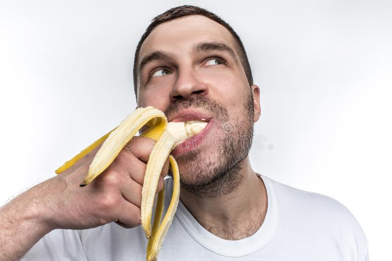 Человек ест банан. Парень с бананом. Мужчина кушает банан. Мужчина ест банан.