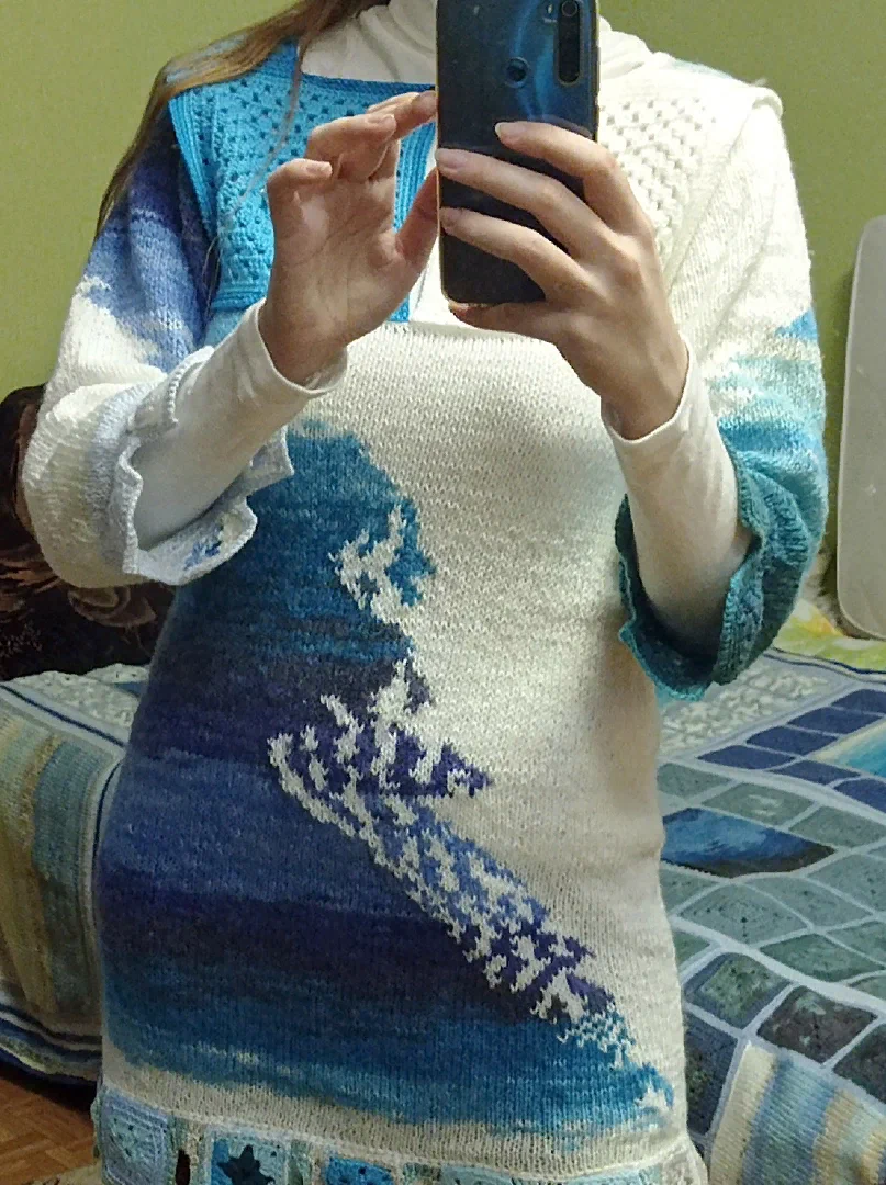 Дочь позирует в свитере, связанном из ниток в стиле батик и белых ниток. На заднем плане просматриваются квадратики морского пледа, связанные из подобных ниток фирмы "Ализе", только другого цветового оттенка. 