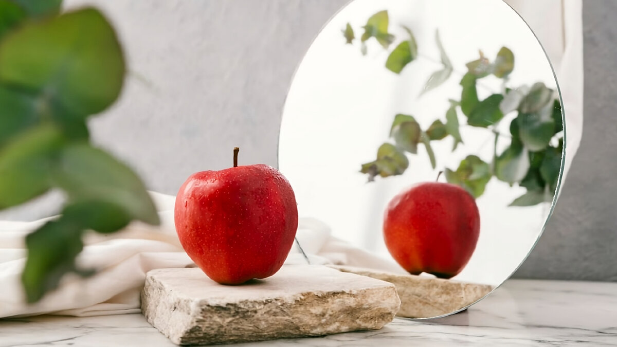 Яблоко отражает красный свет и поглощает все остальные цвета. В зеркале мы видим красное яблоко