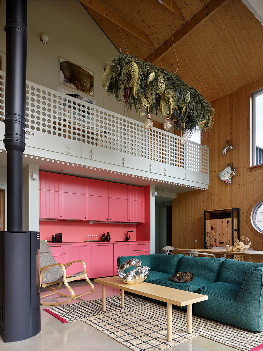 Двусветная гостиная. На переднем плане стол IKEA и диван из мастерской Kreslo. Светильник из стабилизированных цветов сделала студия «Камыш».  Цилиндры под потолком галереи — упаковочный материал из картона. 
