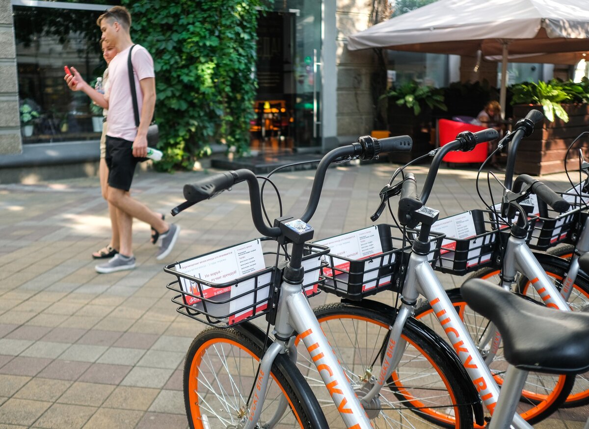 Велошеринг. Оранжевый городской велосипед. Прокатный оранжевый электровелосипед ВЕЛОБАЙК. Велосипедист в городе. Lucky bike
