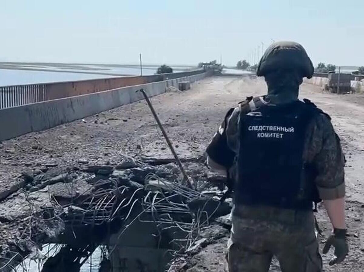    Сотрудник Следственного комитета РФ на поврежденной дороге на Чонгарском мосту. Кадр видео© РИА Новости