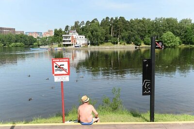    Мужчина у водоема рядом со знаком "Купание запрещено" ©Пелагия Тихонова РИАМО