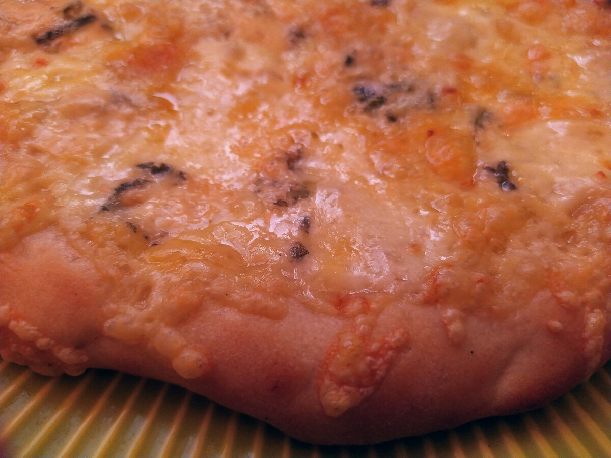 Аппетитный краешек сырной пиццы