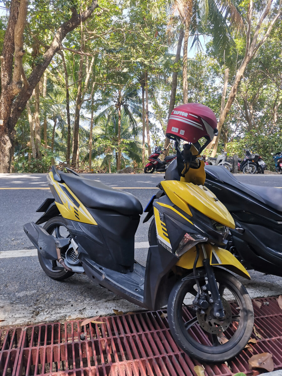 Yamaha GT125. Прекрасного желтого цвета, с царапинами, сообщающими о непростой судьбе скутера. Шлем — без визора, зато красивого цвета.