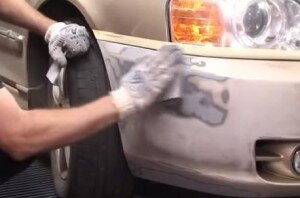 Первый важный этап работы — подготовка бампера. Его тщательно моют, чистят от грязи с помощью порошка и воды. Потом производится обработка растворителем или уайт-спиритом. Это поможет убрать смолы, дорожный битум. Потом следует шлифовка и ликвидация прежнего покрытия, которое может отслаиваться. Поможет нож или острый предмет. При помощи шлифмашинки зачищаются углы и сколы. А в сложных, недоступных точках можно работать наждачкой. Имеющиеся трещины можно ликвидировать при помощи паяльника.