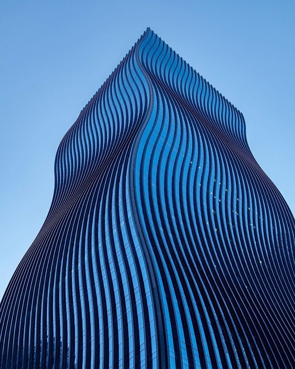 Пьяный🤪 небоскреб в самом престижном районе, который на самом деле не дотягивает до небоскреба, т.к. всего 130м. Создает вау-эффект тающего пломбира, а монохромный фасад отражает окружающие здания как кривое зеркало, усиливая впечатление.  Концепция включает постройку второй башни GT Tower West, с которой она будет образовывать единое целое. Но что-то не заладилось и вторую башню не построили🤷‍♂️

Конструктивно здание опирается на центральное ядро и колонны по периметру. Из-за низкого роста ядро компактное, поэтому на этажах много свободного пространства, планируй офисы как хочешь. Не забыли добавить эко плюшки: термоизолирующее остекление, солнечные батареи, энергоэффективные системы кондиционирования и окна в потолок (очень маленькие рамы, практически сплошное стекло).
Один вход как у всех с улицы, зато второй на минус первом уровне!  Дело в том, что с одной стороны башни вырыт большой двор ниже уровня земли, поэтому здесь здание начинается с минус первого этажа. Сделано, чтобы было спокойное место без уличного шума и суеты, куда можно выйти на свежий воздух))  Внизу есть фото. Попасть во двор с улицы нельзя, только через выход в здании, спустившись вниз. Но на этом не успокоились и прорыли еще 8 подземных уровней😱. И это при высоте 28 этажей! то есть еще треть здания вообще под землей! 

Тут мне сказали, что у людей, работающих в зданиях с искажённым фасадом (окна наискосок и т.п) наблюдаются сильные психические расстройства, в т.ч. увеличивается число самоубийств. Подсознательно мозгу кажется, что здание падает или разрушается, что давит на психику. Особенно, если видеть боковым зрением. Я сам никогда о таком не слышал, как считаете, можно чокнуться, если часто смотреть на такое здание или работать в нем!?🤔🤨