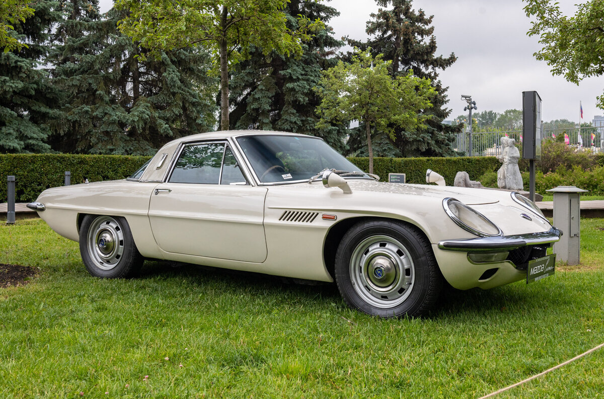    Mazda Cosmo — первый роторный автомобиль, произведенный компанией, выпускался в 1967–1972 годах. Машины собирались вручную, всего было создано 1519 экземпляров. Вот цитата из нашей [подробной статьи о роторных Маздах](https://motor.ru/stories/rotarymazda.htm): «Купе укомплектовали двухсекционным 982-кубовым мотором и четырехступенчатой «механикой». Сперва двигатель развивал 110 л.с., затем отдачу увеличили до 130 сил. Разгон до 96 километров занимал у Cosmo Sport менее 9 секунд, а максимальная скорость превышала 185 км/ч. За маленьким «Космо» с легким мотором не могли угнаться многие американские купе с громоздкими V8».   
Фото: Светлана Парфенова