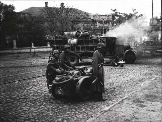 Расстрелянная машина и немецкие мотоциклисты в Мариуполе