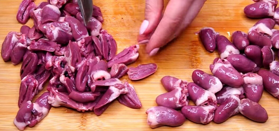 Сердечки промываем, обрезаем лишнее и режем на половинки.