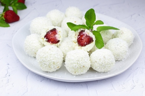 Творожные конфеты с клубникой и шоколадом непременно оценят все сладкоежки. Для начинки будем использовать сочную клубнику, которую спрячем под нежной творожной оболочкой.