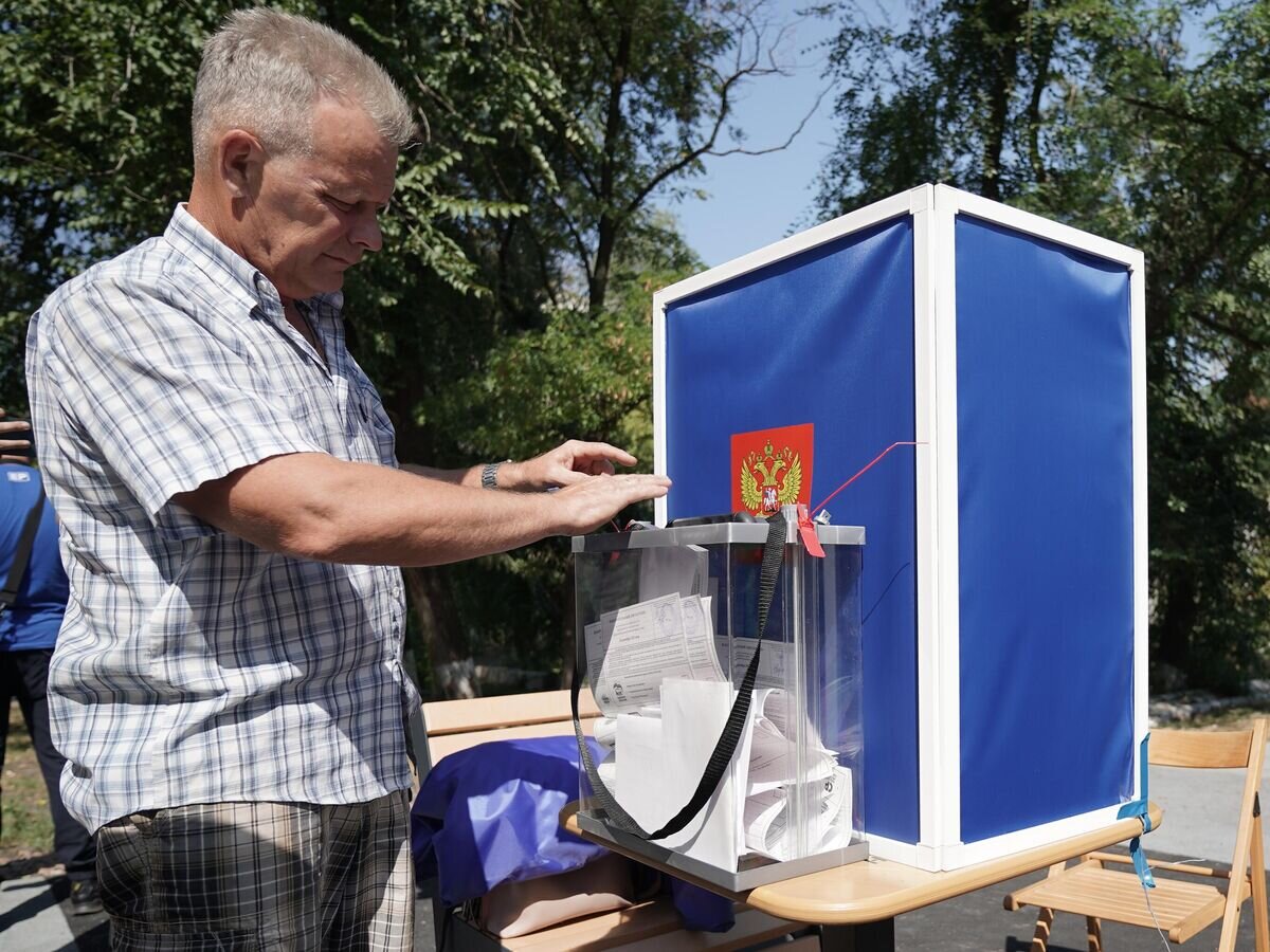    Избиратель во время досрочного голосования на выборах в ДНР в одном из дворов Мариуполя© РИА Новости / Александр Сухов