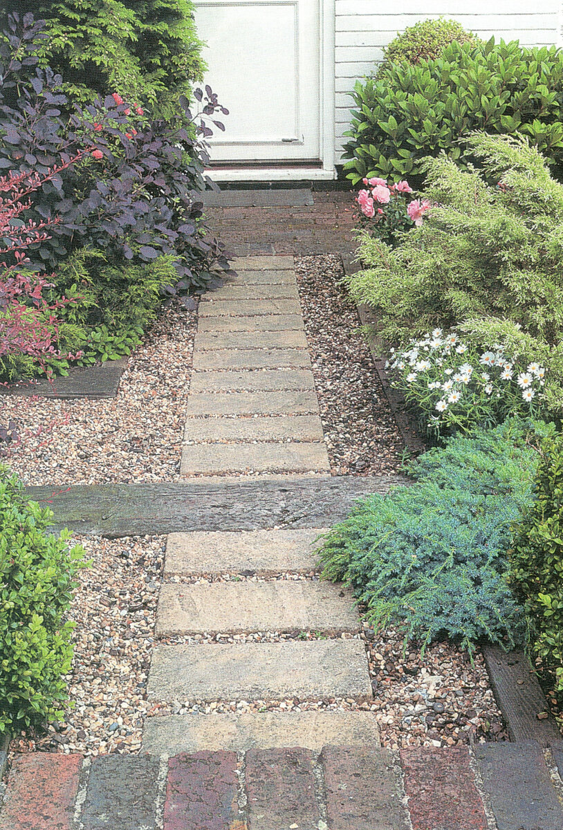 Этот крошечный палисад­ник привлекает внимание сочетанием различных ма­териалов, использованных для покрытия почвы, ко­торые оттеняет довольно незамысловатый растительный фон