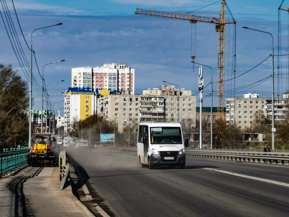 Жизнь на мосту: трактор чистит пешеходный тротуар, а маршрутка уворачивается от пыли.