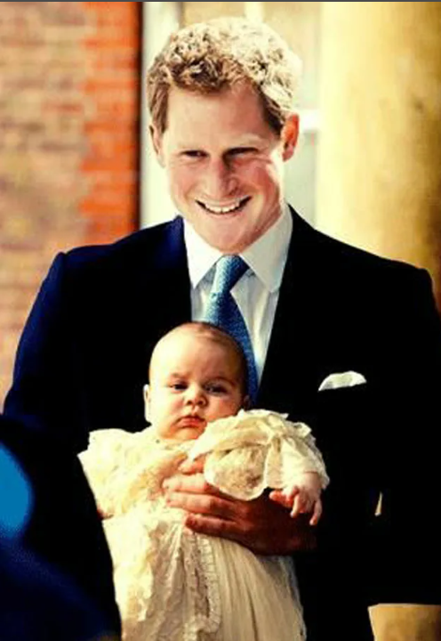 Принц Гарри держит маленького Джорджа. Фото: Getty im.