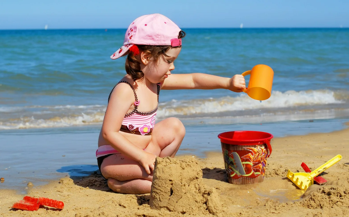 Playing in the sand. Девочка в песочнице. Малыш на пляже. Дети песок море. Малыш в песочнице.