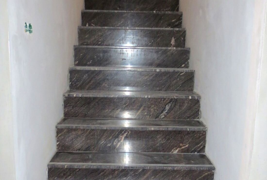  Лестница из мрамора в частном доме. Выполнена облицовка мрамором ступеней, подступеней и площадок лестницы из бетона. На ступенях сделаны противоскользящие насечки (по 3 штуки) во избежание падения.