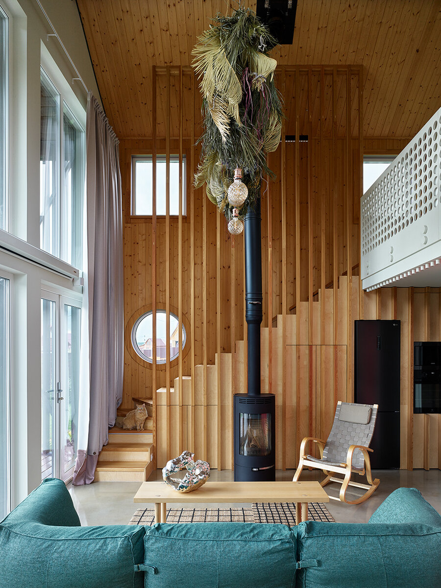 У камина кресло IKEA. Пол — из бетона. Полусухую стяжку тонированную разведенной краской в несколько слоев, а потом покрыли эпоксидной смолой.