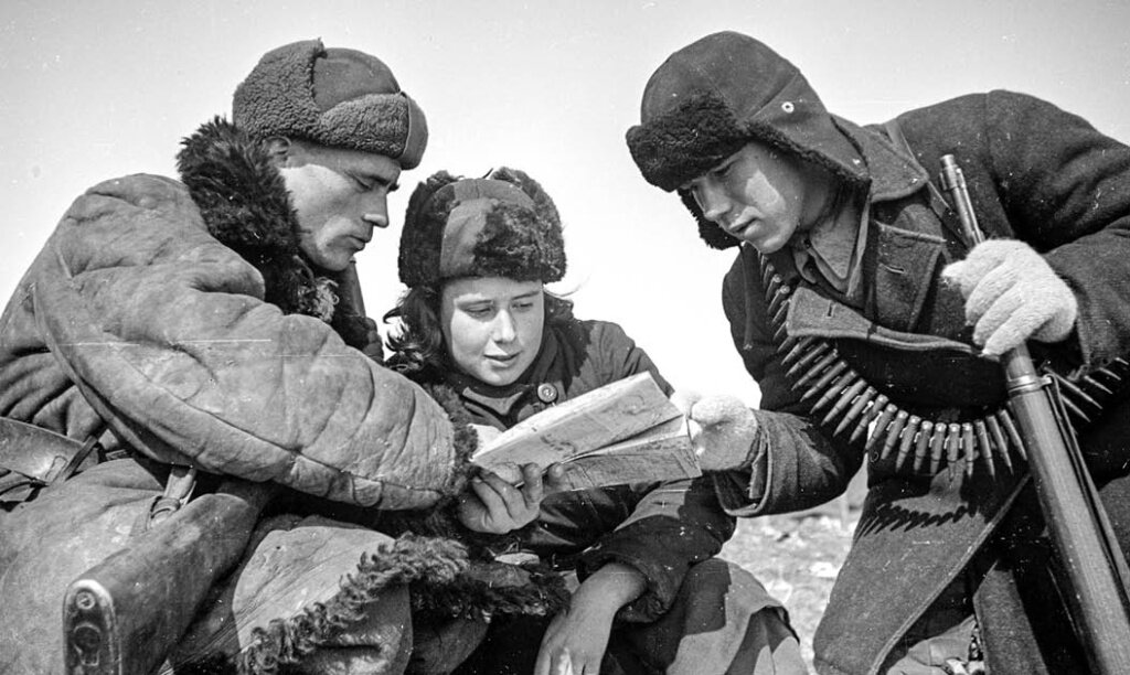 Фото: Командир партизанского отряда Будаков показывает разведчикам Марии Ельник и Павлу Киселёву карту боевых действий в деревне западнее Курска. Партизаны во многом помогали Красной армии перед сражением на Курской дуге. Февраль 1943 г. Фото: Семён ФРИДЛЯНД. 1943 г.