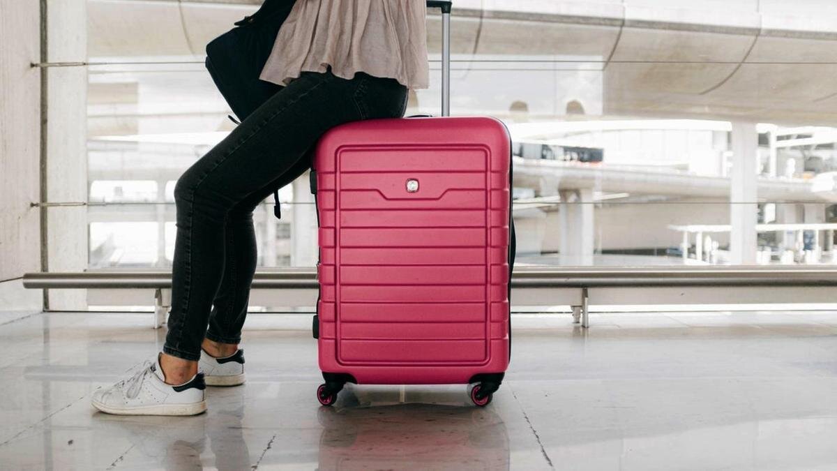    Девушка сидит на багаже в аэропорту:pexels.com