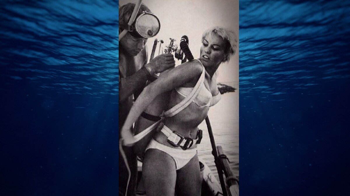 Отдых с подводным плаванием с аквалангом. Девушка плавает под водой
