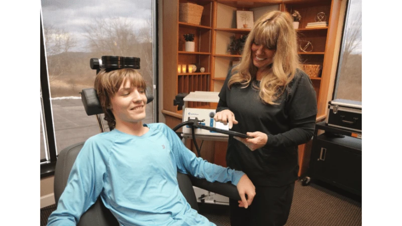 Подросток-аутист проходит курс лечения ПрТМС в присутствии своей матери Мэри Плут. (James Dinonno Studios)