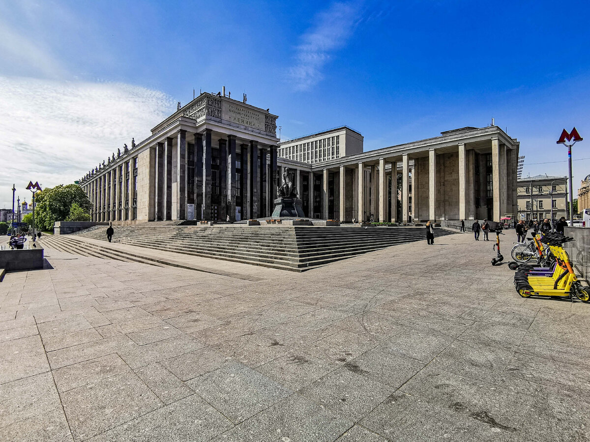 Начнём, конечно, с главной российской библиотеки - Российской государственной библиотеки, бывшей Ленинки. Кстати, станция метро, чьи входы мы видим слева и справа, до сих пор носит старое название библиотеки.  Адрес библиотеки: улица Воздвиженка, 3/5. Фотография сделана 19 мая 2023 года.