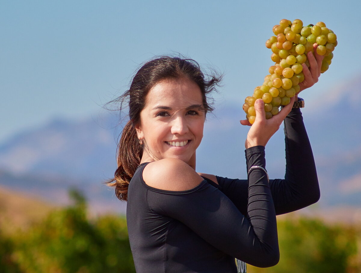 Трейл раннинг забег по виноградникам в Коктебеле, с употреблением вина во время забега.  Девушка — участница забега.