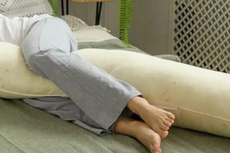 поза для сна на боку с подушкой между ног. спящий человек. подушка для беременных memory foam. подушка для закидывания ноги во время сна. лучшие матрасы для сна.