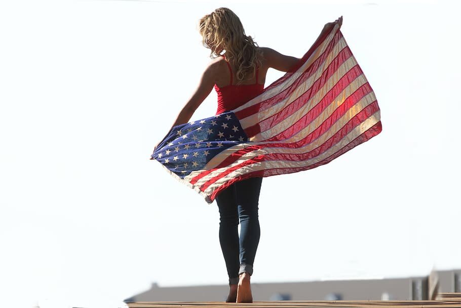 Американочка позирует.
Источник изображения: https://c0.wallpaperflare.com/preview/612/426/571/america-flag-woman-people.jpg