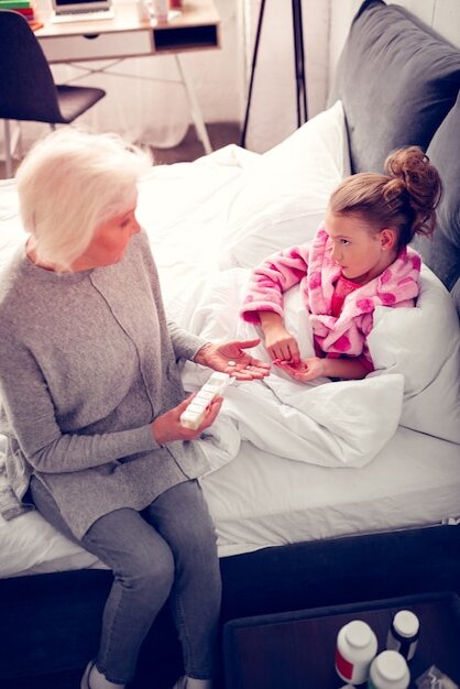 Фото с https://ru.freepik.com/premium-photo/talking-to-granny-granddaughter-feeling-sad-and-sick-while-lying-in-bed-and-talking-to-granny-giving-her-medicine_15474549.htm