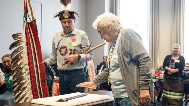 Дорин Лесаж, правнучка вождя Шингуоконсе и член первой нации Гарден-Ривер, стоит рядом с хранителем знаний Дарреллом Буассоно, проводя рукой по трубке, принадлежавшей вождю Шингвоконсе, когда община первых наций предъявляет свои исторические претензии на землю. Законодательному собранию Онтарио в Торонто в четверг, 18 мая 2023 г 